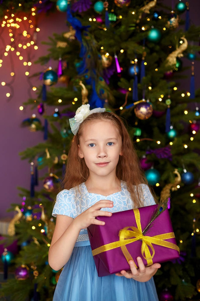 Girl with gift box near christmas tree - Fotoğraf, Görsel