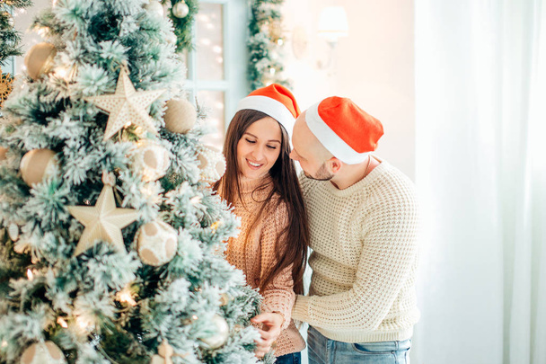 Cute, young couple decorating a Christmas tree - Φωτογραφία, εικόνα