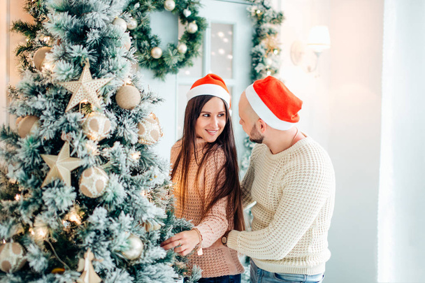 Cute, young couple decorating a Christmas tree - Foto, Imagem