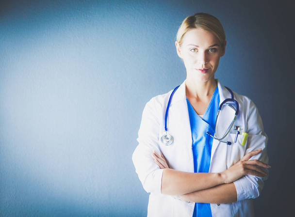 Portrait of young woman doctor with white coat standing in hospital - Photo, image