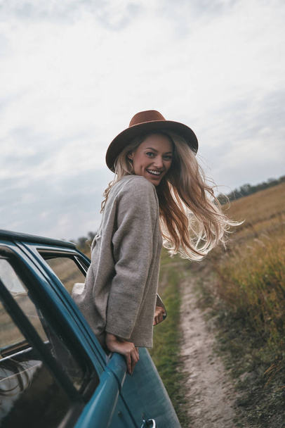 Attractive blonde woman leaning out from van car window and enjoying travel - Photo, Image