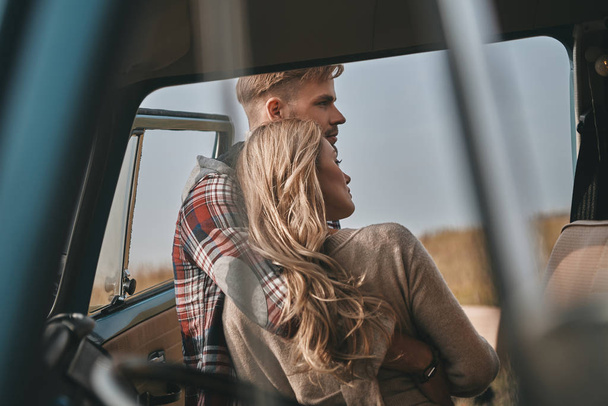 Красивая молодая пара, обнимающая на открытом воздухе возле мини-фургона в стиле ретро
 - Фото, изображение