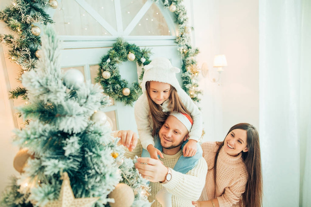 happy girl decorating Christmas tree.Family, christmas, ,happiness concept - Zdjęcie, obraz