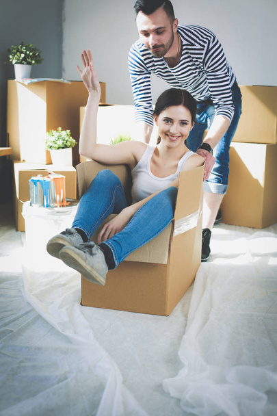 Happy young couple unpacking or packing boxes and moving into a new home. young couple - Fotografie, Obrázek