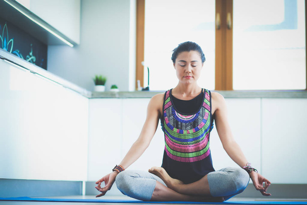 Young woman doing yoga at home in the lotus position. Yoga. Woman. Lifestyle - Photo, Image