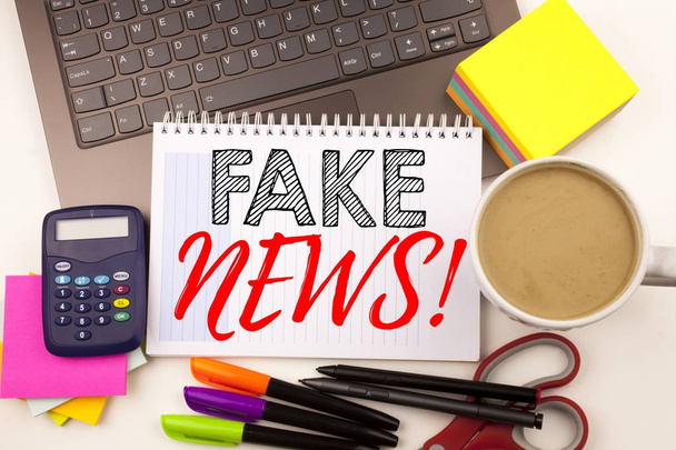 Word writing Fake News in the office with laptop, marker, pen, stationery, coffee. Business concept for Propaganda Newspaper Fake News Workshop white background with copy space - Photo, Image