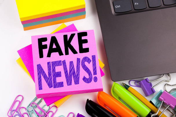 Writing text showing Fake News made in the office with surroundings such as laptop, marker, pen. Business concept for Propaganda Newspaper Fake News Workshop white background copy space - Photo, Image