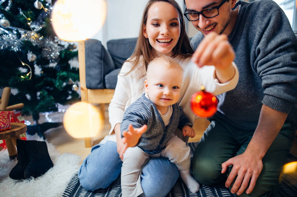 Happy family playing with Christmas balls at home - Photo, Image
