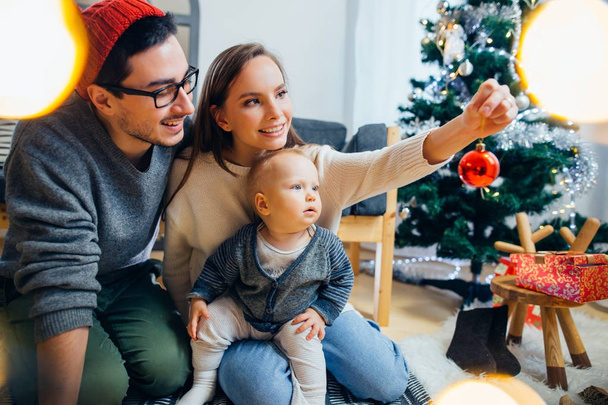 Happy family playing with Christmas balls at home - Φωτογραφία, εικόνα