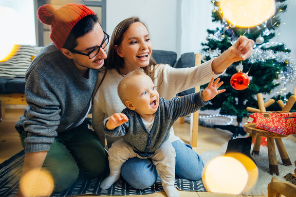 Happy family playing with Christmas balls at home - Фото, зображення