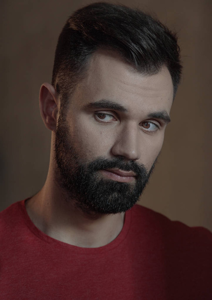 Portrait of bearded man face with stylish hairstyle in red shirt looking to side - Φωτογραφία, εικόνα