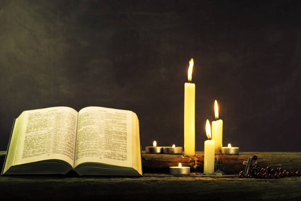 Biblia y vela sobre una vieja mesa de madera de roble. Hermoso fondo.Concepto de religión
 - Foto, Imagen