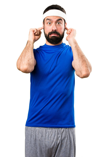Funny sportsman covering his ears on isolated white background - Foto, afbeelding