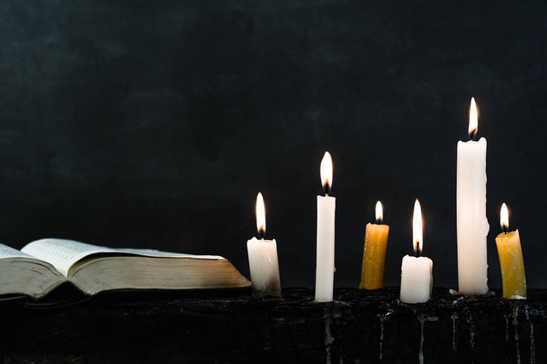 Біблійне розп'яття та бісер зі свічкою на старому дерев'яному згорілому столі. Гарний фон. Концепція релігії
. - Фото, зображення