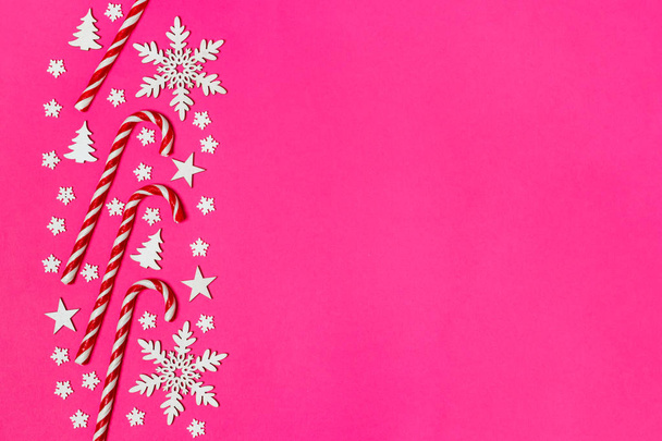 Joulukarkkia ruoko makasi tasaisesti peräkkäin vaaleanpunainen tausta koriste lumihiutale ja tähti. Tasainen lay ja ylhäältä näkymä
 - Valokuva, kuva
