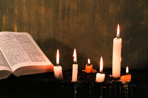 Biblia feszület és gyöngyök egy táblán régi fa égett gyertyát. Gyönyörű háttér. A vallás fogalma. - Fotó, kép
