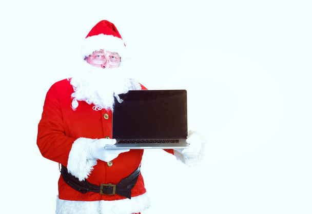 Santa Claus presents a laptop on white background - Valokuva, kuva