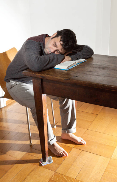 portrait of man sleeping on the wooden table - Foto, Imagen
