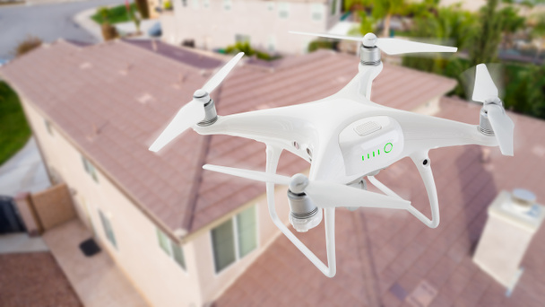 İnsansız uçak sistemi (İHA) Quadcopter dron çatı teftiş ev üzerinde havada. - Fotoğraf, Görsel