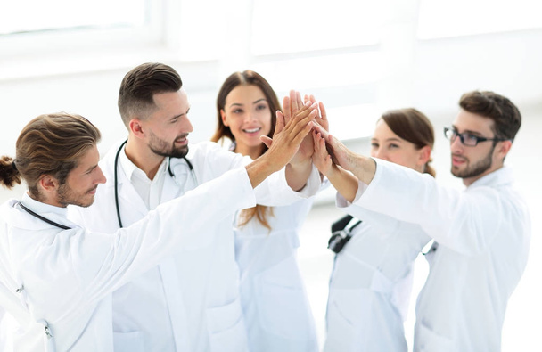 group of doctors giving each other a high five. - Zdjęcie, obraz