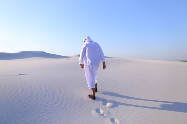Wesoły facet muzułmańskich spacery połacie pustyni z uśmiechem - Zdjęcie, obraz