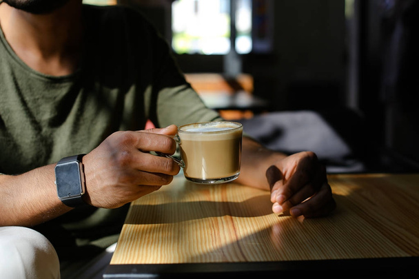 Homem de negócios árabe à espera de parceiro e beber café em s
 - Foto, Imagem