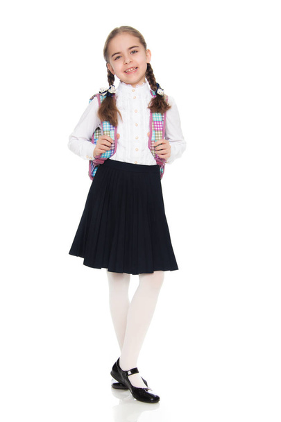 Beautiful schoolgirl with a backpack behind her shoulders. - Foto, imagen