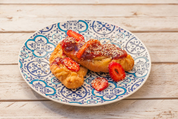 Pastel de queso griego gourmet con mermelada de tomate y fresas servidas en un plato con patrón
 - Foto, imagen