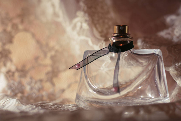 parfumfles op guipure stof - Foto, afbeelding