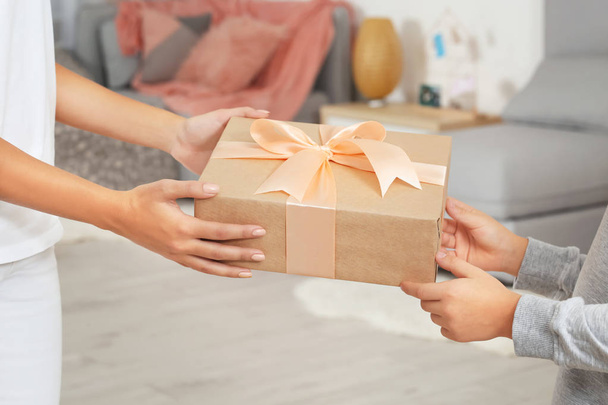 Young woman receiving Mother's Day gift from her little son at home, closeup - 写真・画像