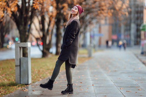 Beautiful fashion girl walk on the street with bag and smile to  - Valokuva, kuva