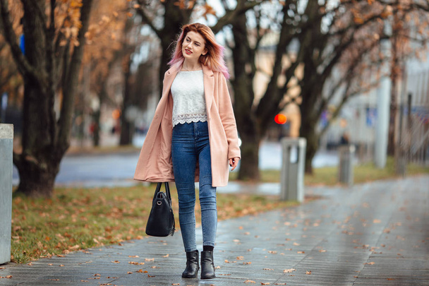 Beautiful fashion girl walk on the street with bag and smile to  - Фото, зображення