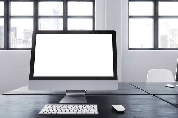 White computer screen on a black office table - Fotó, kép