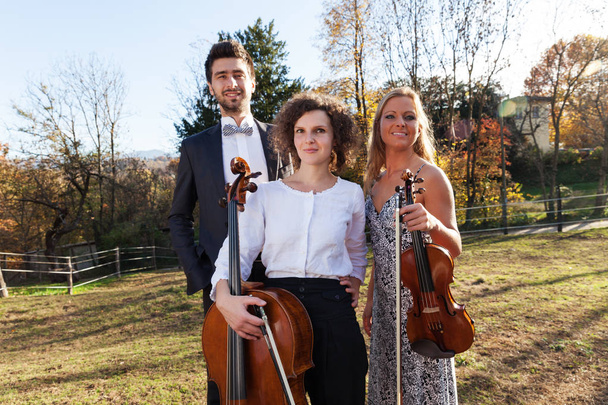three young musicians, outdoors - Фото, изображение