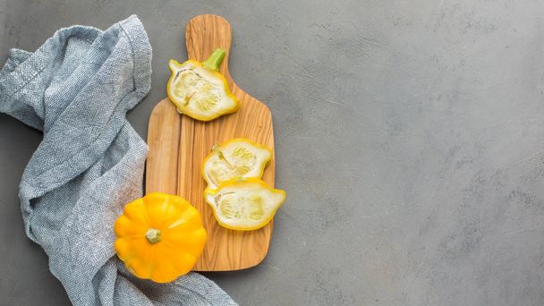 Pequeñas calabazas naranjas (calabazas) sobre un tablero de madera sobre un fondo claro de hormigón con semillas
.  - Foto, imagen