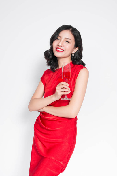 portrait of amazing luxury asian woman in stylish red party dress holding glass of champagne - Foto, Imagen
