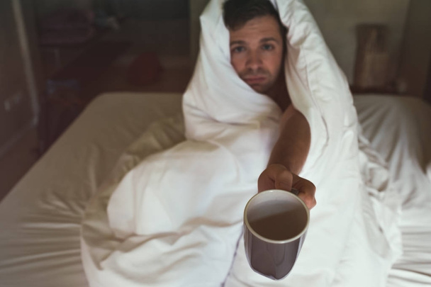 Καυκάσιος αρσενικό με έλλειψη ύπνου, επειδή έχει stting γρίπη στο κρεβάτι και να ζητήσει για το νερό ή ιατρικής - Φωτογραφία, εικόνα