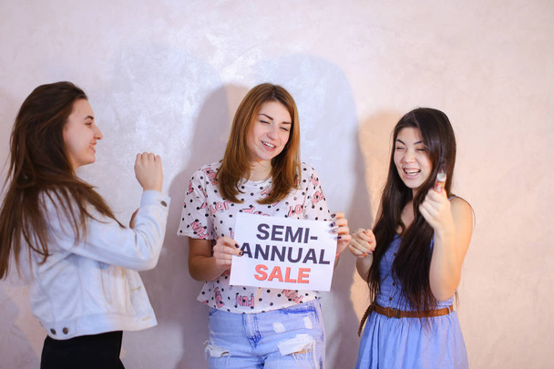 Three stylish female friends posing with sign and calling for sh - Photo, Image
