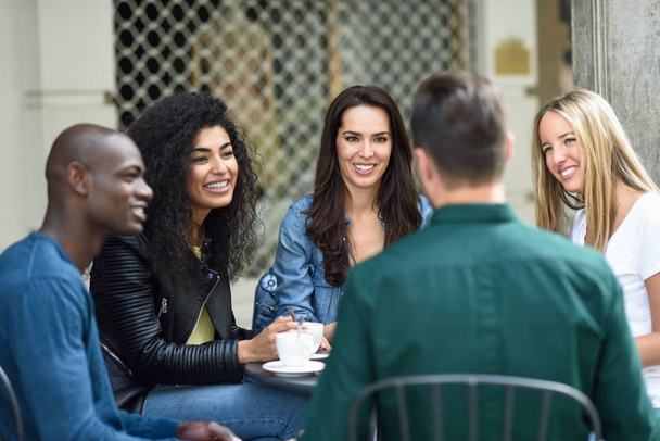Grupo multirracial de cinco amigos tomando un café juntos
 - Foto, Imagen