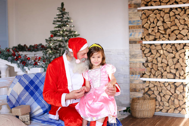 Cheerful Santa Claus talking to little girl. - Photo, Image
