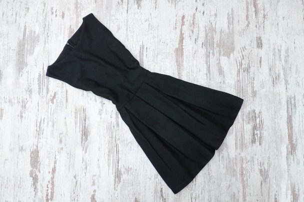 Malé černé šaty. Dřevěné pozadí, módní pojem - Fotografie, Obrázek