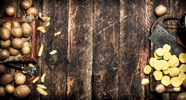 The sliced potatoes on an old wooden Board. On wooden background. - Fotografie, Obrázek
