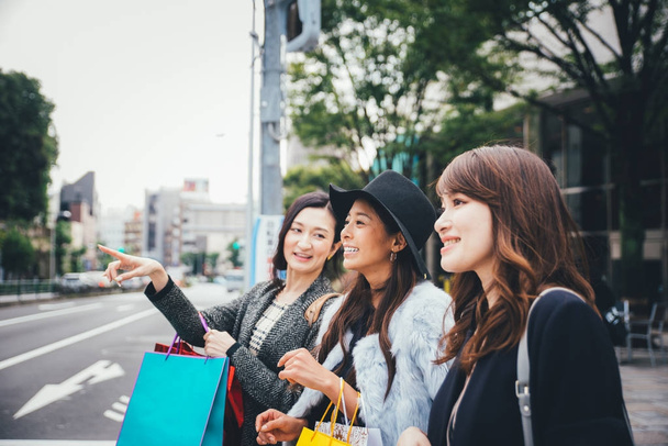 Group of japanese women spending time in Tokyo, making shopping  - Фото, изображение