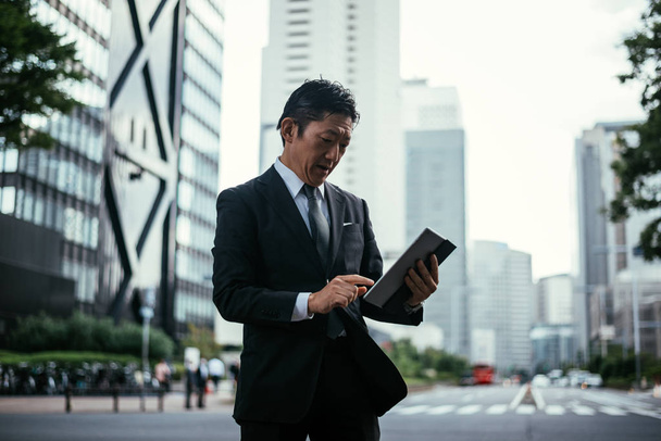 Senior business man moments on the streets of Tokyo - Photo, Image
