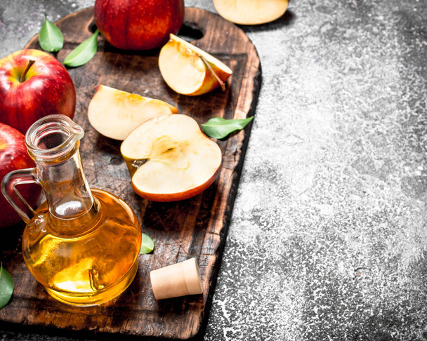 Apple cider vinegar with fresh apples on cutting Board. - Foto, Bild