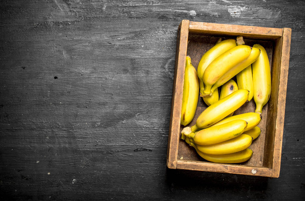 Fresh bananas in an old box. - Foto, imagen