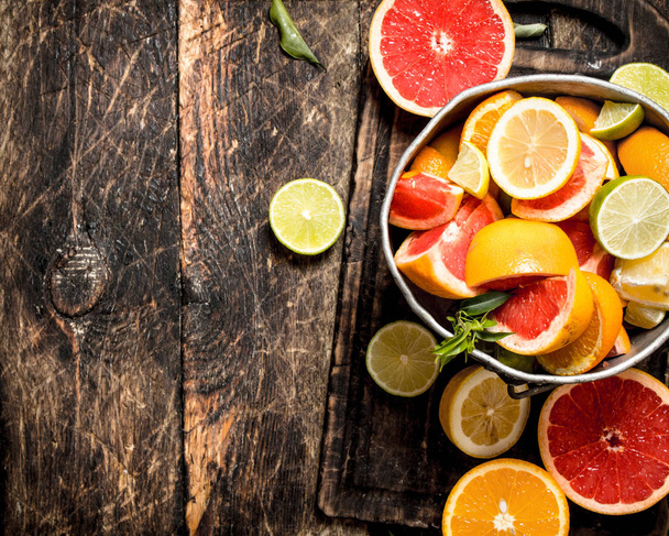 Citrus background. Fresh citrus fruits in the old bucket. - Photo, Image