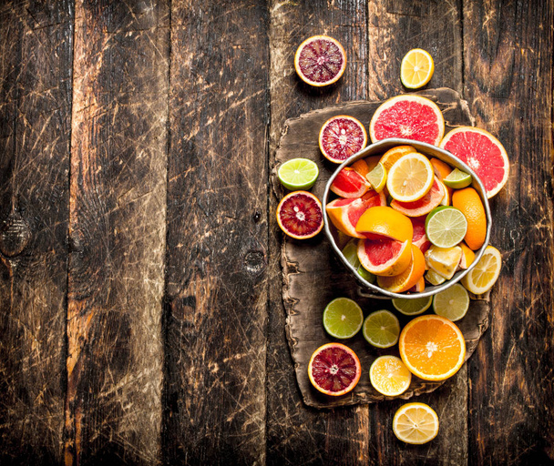 Citrus background. Fresh citrus fruits in the old bucket. - Photo, Image
