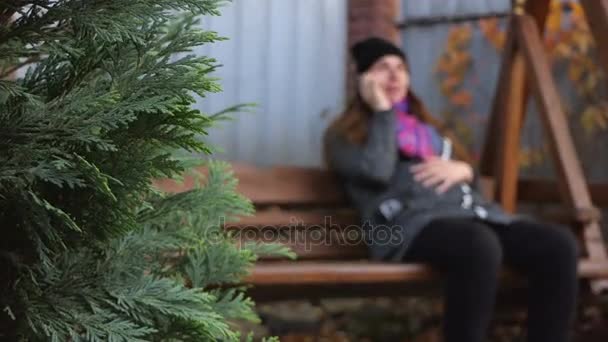 Pěkný těhotná žena houpe na dřevěnou lavici v slo-mo - Záběry, video