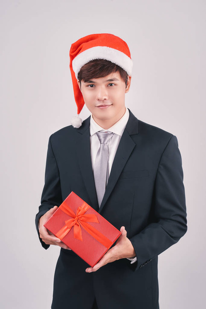 sonriente asiático hombre de negocios en santa hat holding rojo regalo caja
 - Foto, Imagen